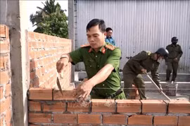 Police officers and soldiers help build a house for the needy. (Photo: VNA)