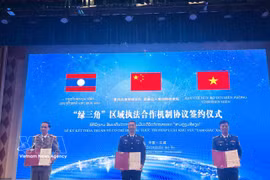 Representatives of Vietnam, China and Laos sign the new trilateral law enforcement cooperation mechanism on March 25. (Photo: VNA)