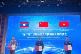 Representatives of Vietnam, China and Laos sign the new trilateral law enforcement cooperation mechanism on March 25. (Photo: VNA)