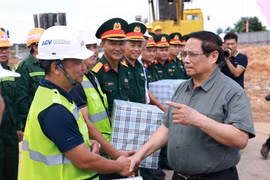Prime Minister Pham Minh Chinh (R) meets with the units constructing Terminal 2 of Dong Hoi Airport (Photo: VNA)