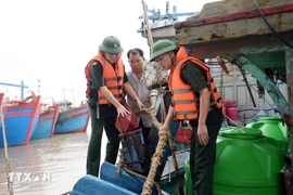 Military officers assist fishermen in Hai Thinh commune, Ninh Binh province, to gear up for the storm. (Photo: VNA)