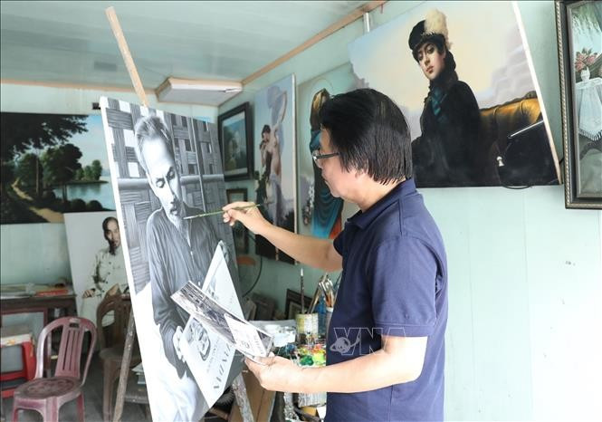 Artist Tran Hoa Binh paints a portrait of President Ho Chi Minh. (Photo: VNA)
