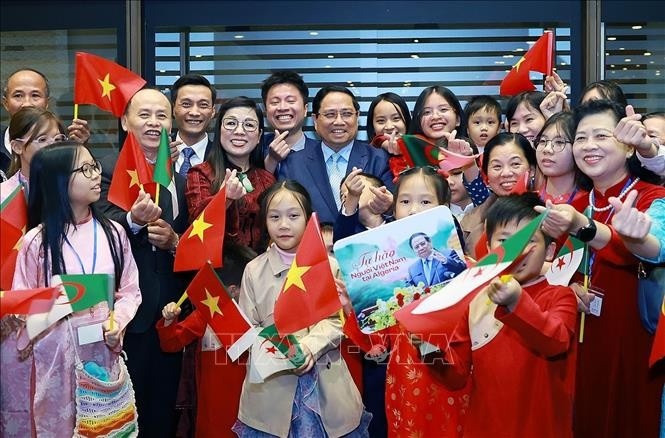 Prime Minister Pham Minh Chinh and his spouse, with Vietnamese Embassy staff and community in Algeria. (Photo: VNA)