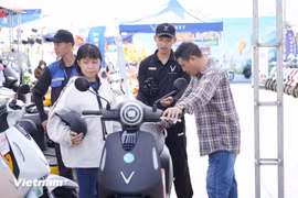 Consumers test an e-motorcycle of VinFast. (Photo: VNA)