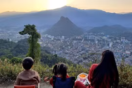 Tourists view the sunset over Ha Giang city from the Mo Neo Mountain. (Photo: VNA)