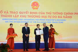 Deputy Prime Minister Nguyen Hoa Binh (second from right) presents the Prime Minister's decision to establish the Da Nang Free Trade Zone on June 22. (Photo: VNA)