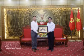 Secretary of the Bac Ninh Party Committee Nguyen Hong Thai (right) presents a Dong Ho folk painting as a gift to the delegation of Chinese investors at the meeting on September 21. (Photo: VNA)