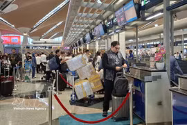 Passengers handle boarding procedures at Kuala Lumpur International Airport of Malaysia. (Photo: VNA)