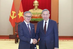 Party General Secretary To Lam (R) receives visiting Lao Minister of Foreign Affairs Thongsavanh Phomvihane in Hanoi on February 13. (Photo: VNA)