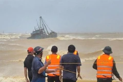 Rescue forces assist a fishing boat stranded at the breakwater of Cua Viet channel. (Photo courtesy of the Quang Tri Border Guard)