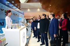 PM Pham Minh Chinh (second from right) inspects the display of outstanding products. (Photo: VNA)