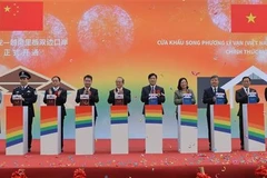 Leaders of Cao Bang province and Ha Lang district, along with representatives of Daxin county (China), press the button to inaugurate the Ly Van – Shuo Long border gate. (Photo: VNA)