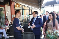 PM Pham Minh Chinh (centre) and his spouse visit the family of Vo Ba Luan - the owner of a restaurant in Nice. (Photo: VNA)