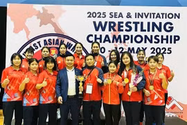 Vietnamese coaches and athletes pose with their golds and trophy from the Southeast Asian and Invitation Wrestling Championships which closed on May 12 in Singapore. (Photo: Vietnam Sports Team)