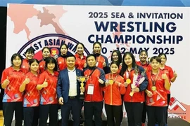 Vietnamese coaches and athletes pose with their golds and trophy from the Southeast Asian and Invitation Wrestling Championships which closed on May 12 in Singapore. (Photo: Vietnam Sports Team)