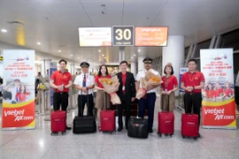 A leader of Vietjet welcomes the inaugural Hanoi – Chengdu flight alongside the flight crew and passengers at Noi Bai International Airport. (Photo: Vietjet)