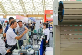 Visitors explore the exhibition booths at the Vietnam International Door Industry Exhibition 2025. (Photo: VNA)