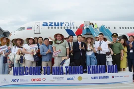 Russian tourists pose for photos with representatives from Khanh Hoa province (Photo: VNA)