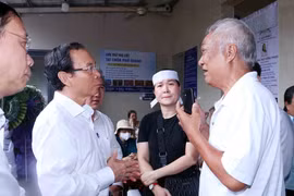 Nguyen Van Nen, Politburo member and Secretary of the Ho Chi Minh City Party Committee (second from left), offers condolences to the families of the victims in the Doc Lap apartment fire. (Photo: VNA)