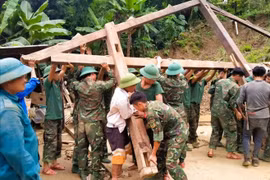 Officers and soldiers of the Tram Tau district armed forces help a poor household in Hat Luu commune build a new house. (Photo: thanhtra)