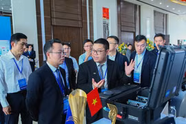 Delegates explore the exhibition space showcasing AI technological achievements. (Photo: VNA)