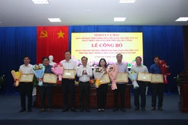 Pham Van Thieu, Chairman of the Ca Mau Provincial People’s Council, presents certificates of merit to individuals in recognition of their outstanding contributions to the province’s completion of the programme to eliminate temporary and dilapidated houses. (Photo: VNA)