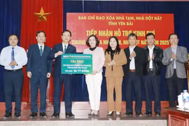 Representatives from Yen Bai province receive a symbolic plaque of a 36 billion VND donation from BIDV for eradicating temporary and dilapidated houses. (Photo: VNA)