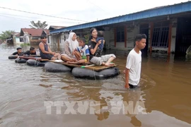 Residents in Pekanbaru, Indonesia's Riau province, evacuate from flooded areas on March 6, 2025 after heavy rains. (Photo: VNA/Xinhua)