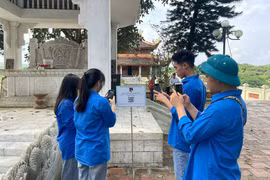 Youth union members in Ha Hoa township scan a QR code to learn about the Man Pagoda historical site. (Photo: baophutho)