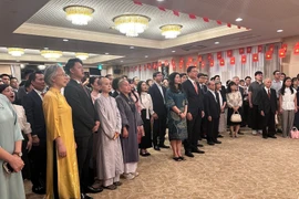 The Vietnamese community in Japan performs the flag-raising ceremony during the celebration. (Photo: VNA)
