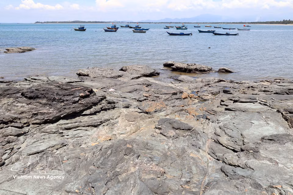 Black rock outcrops at Ban Than stretch towards the sea. (Photo: VNA)