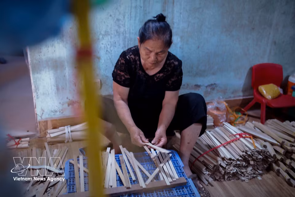 Sau, a craftswoman with 50 years of experience, carefully selects the main bamboo ribs for the fan. (Photo: VNA)