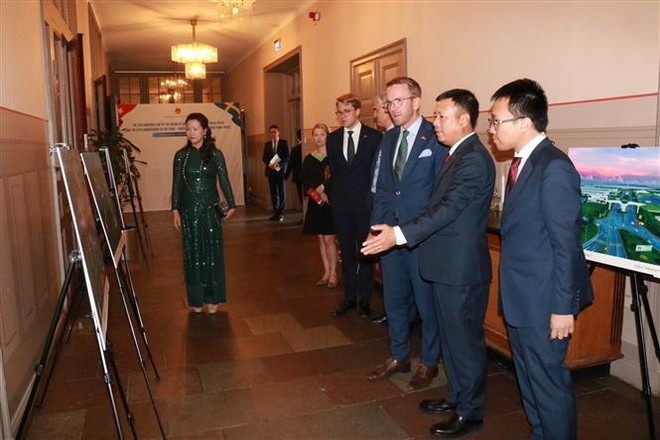 Ambassador Tran Van Tuan introduces a photo exhibition about Vietnam to Andreas Carlson, Minister of Infrastructure and Housing of Sweden. (Photo: VNA) vna_potal_dien_dan_doanh_nghiep_viet_nam_–_thuy_dien_2024_hop_tac_vi_mot_tuong_lai_phat_trien_ben_vung_072551377_7577864.jpg