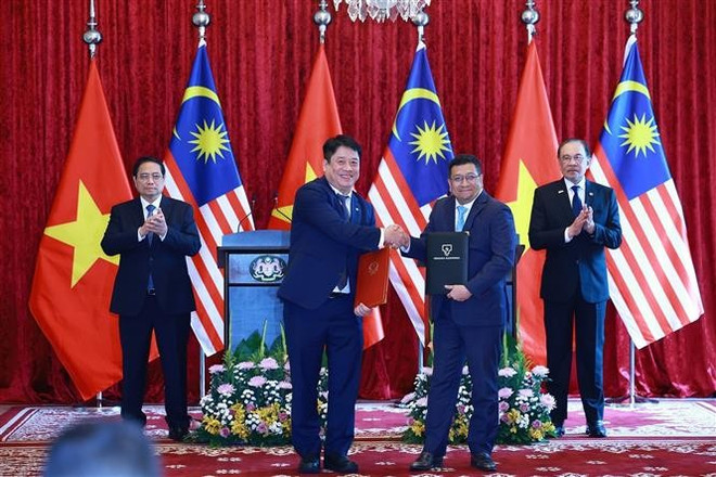 Vietnamese Prime Minister Pham Minh Chinh and his Malaysian counterpart Anwar Ibrahim on May 25 witness the signing of a memorandum of understanding on cooperation between Vietnam Electricity (EVN) and Tenaga Nasional Berhad (TNB) – Malaysia’s national power utility. (Photo: VNA) pham-minh-chin-anwar-ibrahim-cooperation-pact-vna.jpg