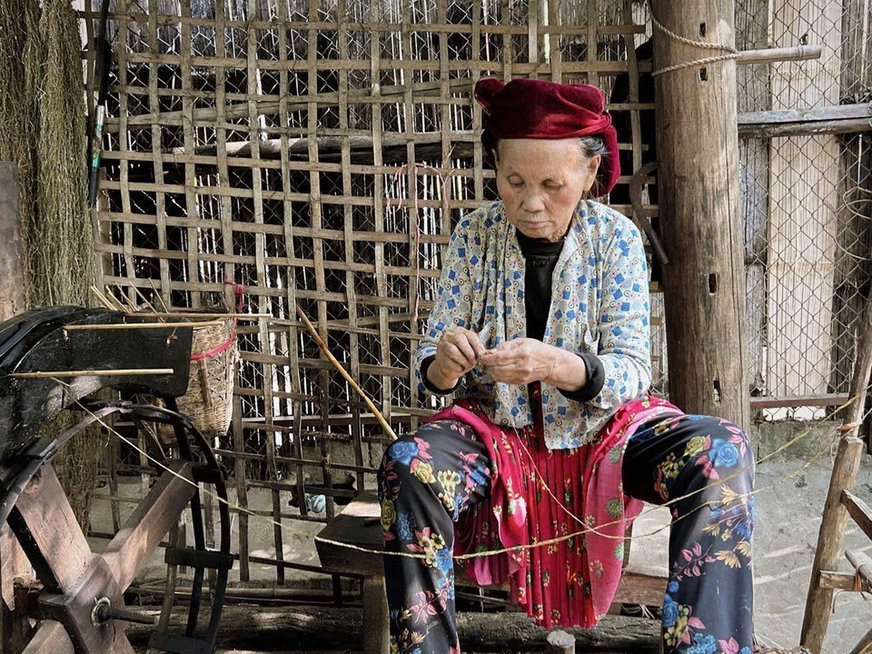 An artisan carefully spins and joins hemp threads by hand. (Photo: VNA)
