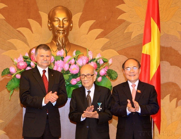 National Assembly Chairman Nguyen Sinh Hung and Hungarian Speaker László Kövér congratulate Professor Vu Khieu on receiving Hungary’s Knight’s Cross Order of Merit (Hanoi, November 9, 2015). (Photo: VNA)