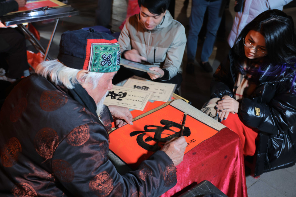 Tet is really a golden chance for children to visit those scholars to ask for parallel sentences which are believed to bring some of the scholars’ erudition and luck to their home. (Photo: VNA)