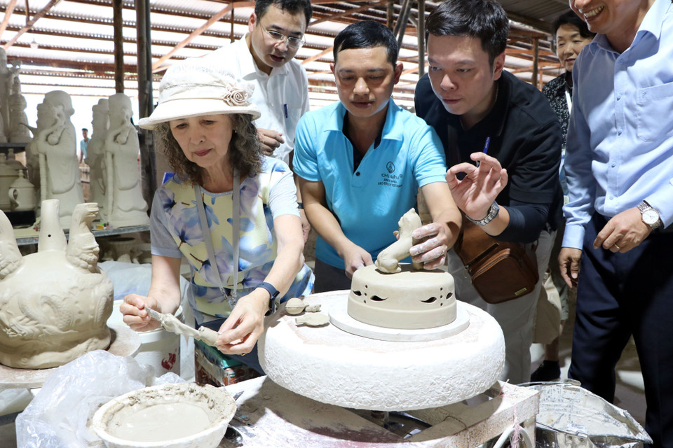 Foreign guests explore the intricate pottery-making process. (Photo: VNA)