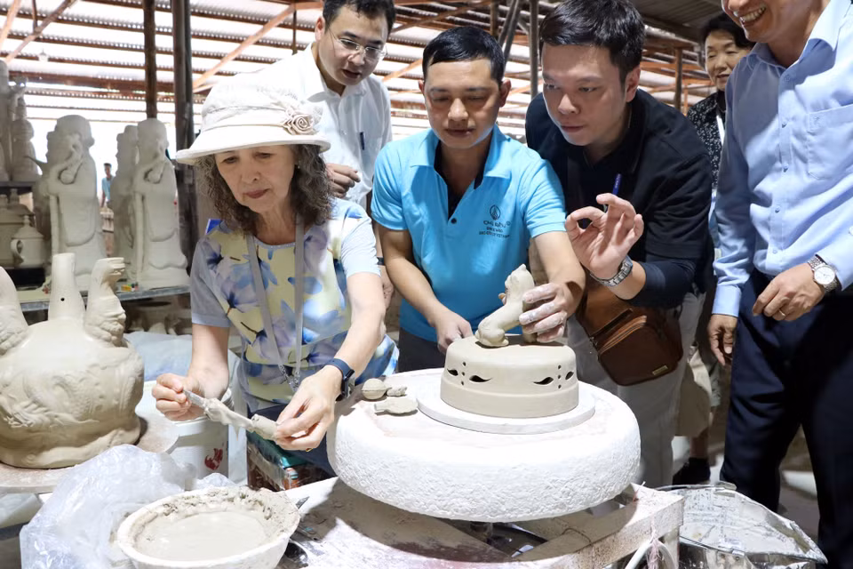Foreign guests explore the intricate pottery-making process. (Photo: VNA)