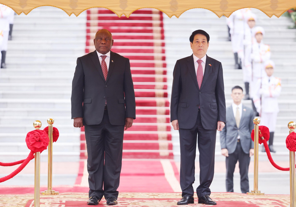 State President Luong Cuong and South African President Matamela Cyril Ramaphosa listen to the national anthems of both countries performed by the military band. Photo: VNA