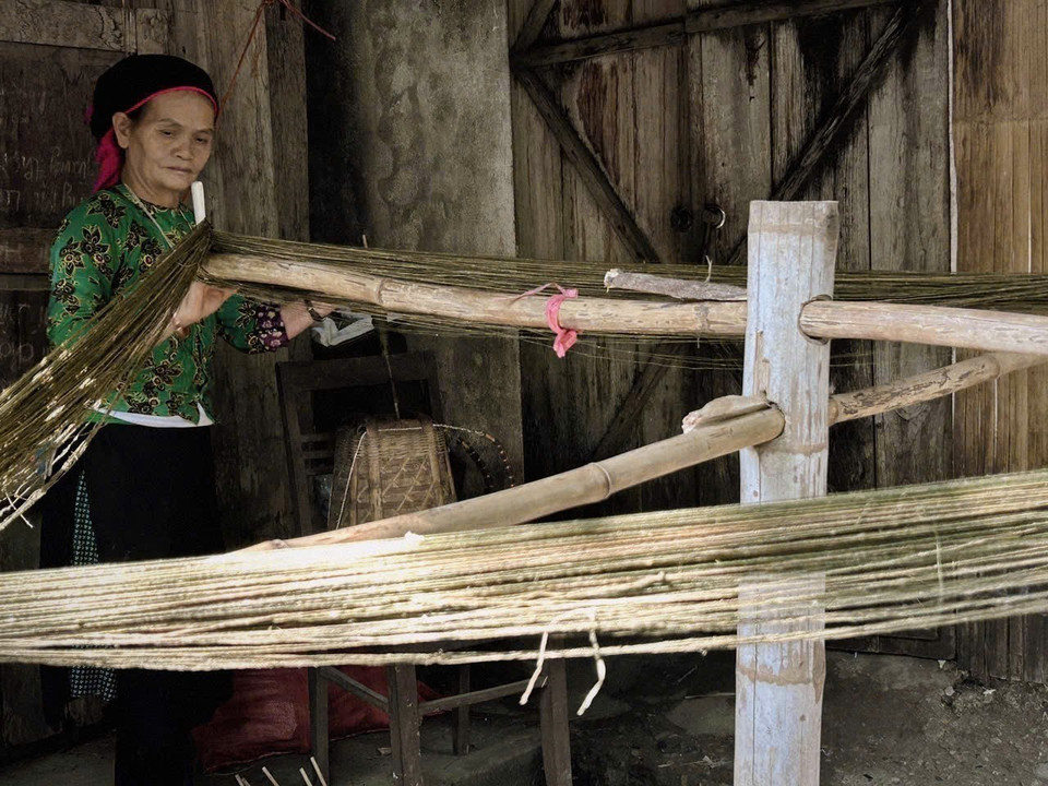 Setting up the warp threads in preparation for the weaving process. (Photo: VNA)