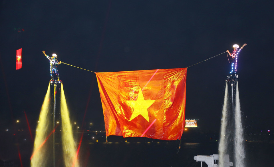 Flyboard athletes display the Vietnamese national flag above the Dong Nai River. (Photo: VNA)