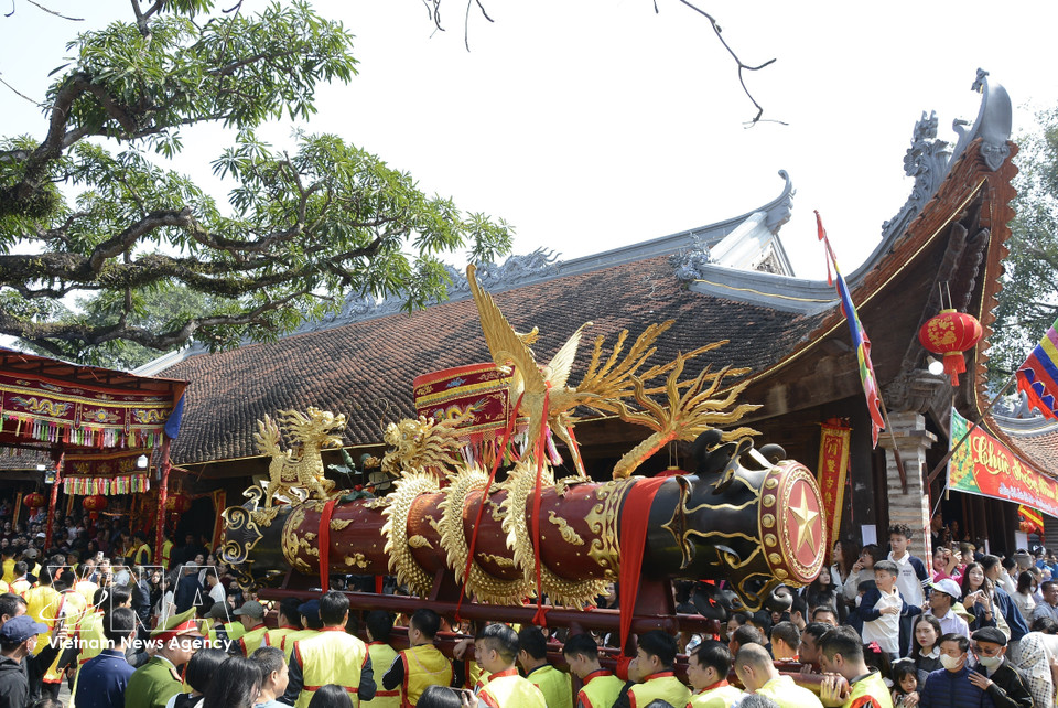 Around 11 a.m, the firecracker is processed back to the village communal house for the ceremony. (Photo: VNA)