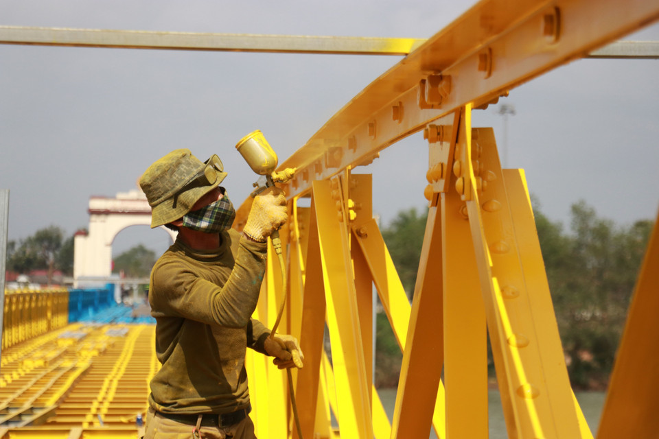 A worker repaints the bridge railing. (Photo: VNA)