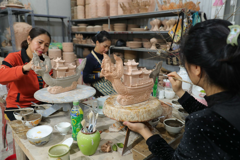 Applying glaze to the ceramic artwork “Ngu Long Khanh Hoi” at artisan Nguyen Trong Nghia’s workshop in Bat Trang. (Photo: VNA)