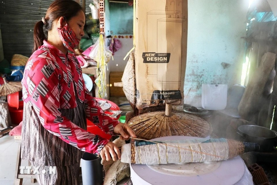 Removing the freshly steamed rice paper requires dexterity to avoid tearing or breaking it. (Photo: VNA)