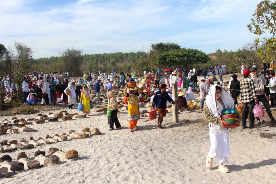 Cham people, dressed in traditional attire, bring offerings to the ceremony. (Photo: VNA)