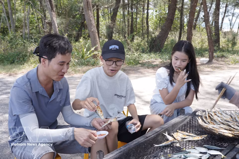 Visitors enjoy grilled herring on the beach in Ben Hai commune. (Photo: VNA)