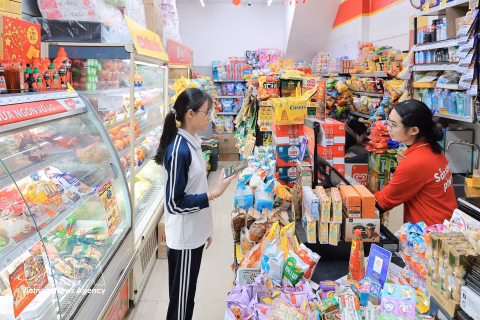 People make electronic payments when shopping, contributing to the growth of cashless consumption. (Photo: VNA)