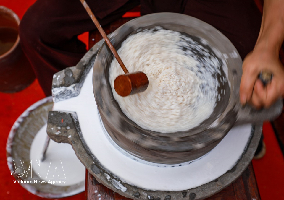 Grinding rice using traditional stone mills. (Photo: VNA)